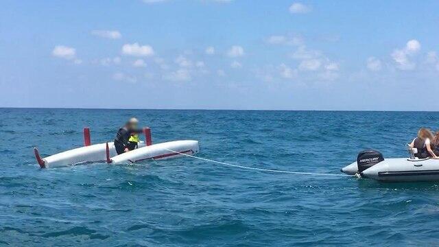Dingy dragging the capsized catamaran