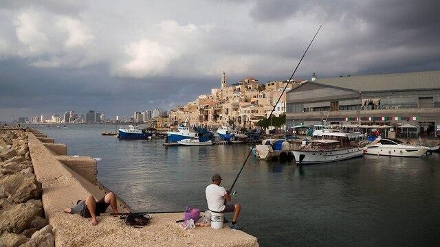 A fisherman in Jaffa, Tel Aviv in the background