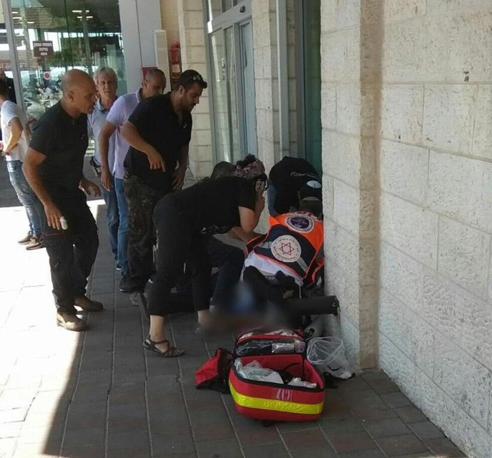 Парамедики оказывают помощь раненому. Фото: Йоси Вайцман, оперативная съемка МАДА (צילום: יוסי ויצמן, תיעוד מבצעי מד"א) Парамедики оказывают помощь раненому. Фото: Йоси Вайцман, оперативная съемка МАДА