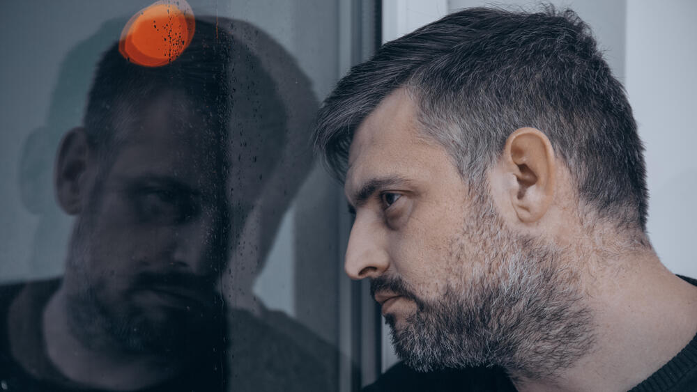 גבר מסתכל על בבואתו ומהרהר