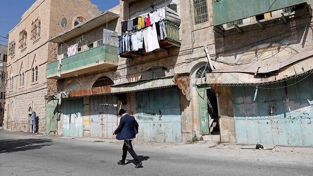 A settler walks the streets of Hebron (file photo)