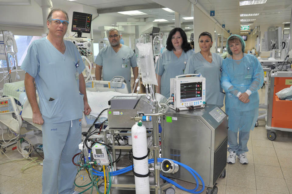 На фото – д-р Эден и персонал отделения интенсивной терапии возле прибора ЕСМО. Фото: Эли Дадон (пресс-служба больницы "Кармель")