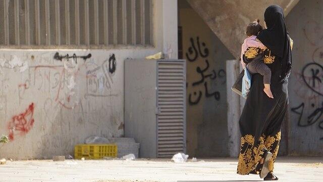 A woman and her child walk in Rahat