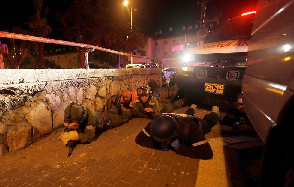 Soldiers stationed near the Gaza border take cover during rocket barrage