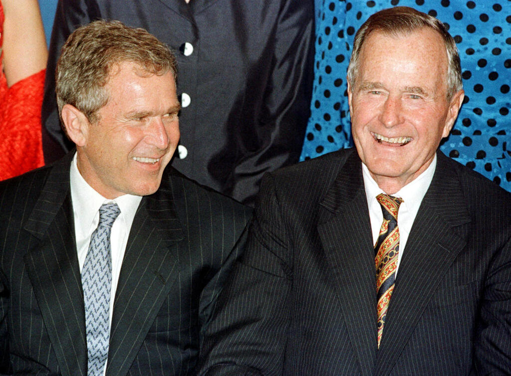 George W. Bush and George H. W. Bush (Photo: AFP) ג'ורג בוש האב וג'ורג בוש הבן