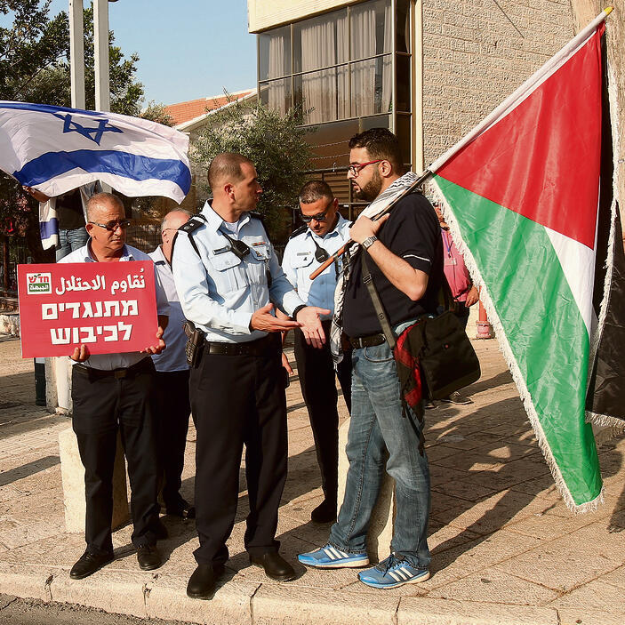 Raja Za'atara raises Palestinian flag during demonstration 