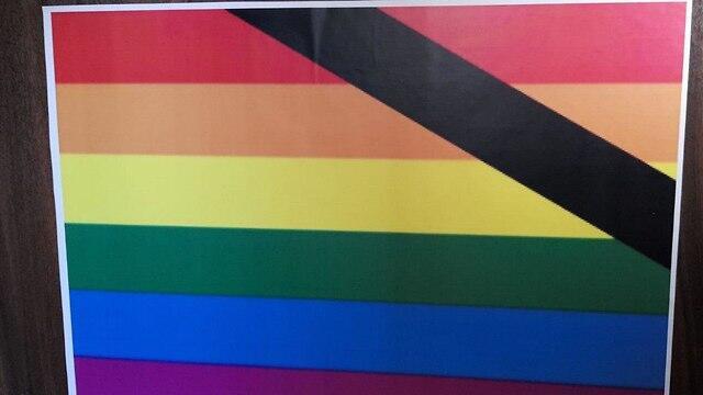 A poster that was put up outside home of men who have a Rainbow Flag on their balcony