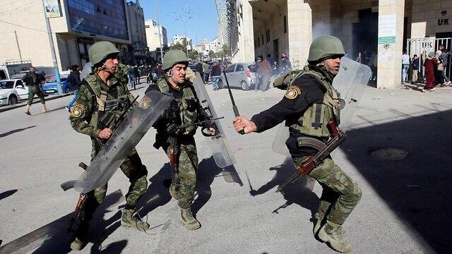 Members of the PA security forces face Hamas protests in the West Bank (Photo: Reuters) (צילום: רויטרס) Members of the PA security forces face Hamas protests in the West Bank (Photo: Reuters)