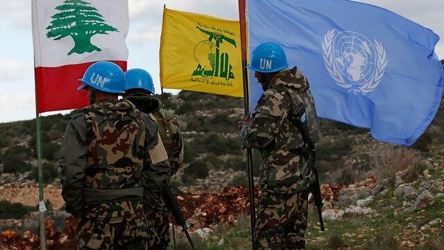 UN peacekeepers hold their flag while standing next to Hezbollah and Lebanese flags along the border (Photo: AP) UN peacekeepers hold their flag while standing next to Hezbollah and Lebanese flags along the border