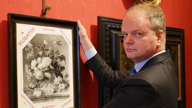 The director of the Uffizi Gallery Eike Schmidt holds onto a copy of still-life “Vase of Flowers” by Dutch artist Jan van Huysum 