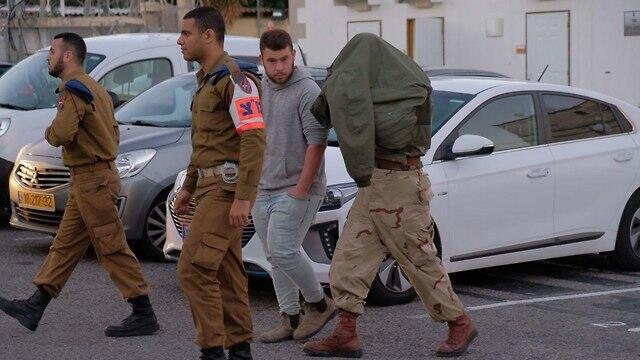 One of the soldiers being brought into court
