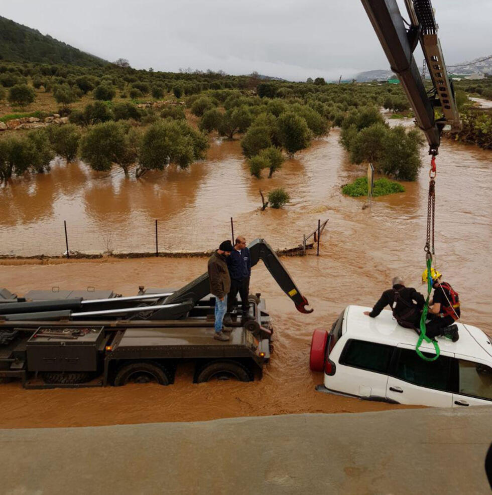 Drivers being evacuated during the flood in Hilazon stream (צילום: דוברות המשטרה) Drivers being evacuated during the flood in Hilazon stream
