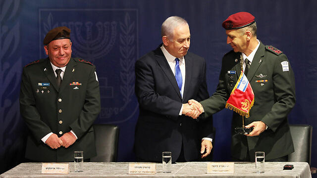 Outgoing IDF chief Gadi Eisenkot looks on as Prime Minister and Defense Minister Netanyahu shakes hands with new IDF Chief of Staff Aviv Kochavi