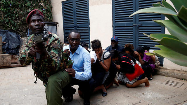 Kenyan security forces lead the survivors of the attack away from the hotel (צילום: רויטרס) Kenyan security forces lead the survivors of the attack away from the hotel