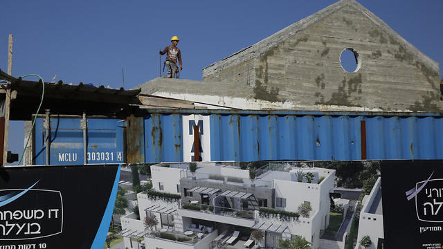 A Palestinian works on a new housing project in the West Bank settlement of Naale