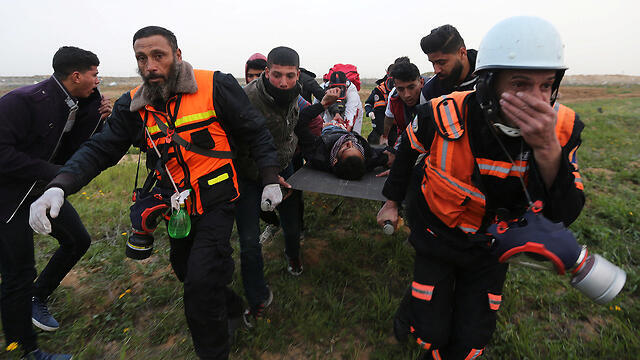 Palestinians carry away one of the wounded protesters