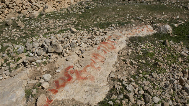 Hebrew graffiti is seen on a rock, that Palestinian villagers say was made by neighboring Israeli settlers (Photo: AP) Hebrew graffiti is seen on a rock, that Palestinian villagers say was made by neighboring Israeli settlers