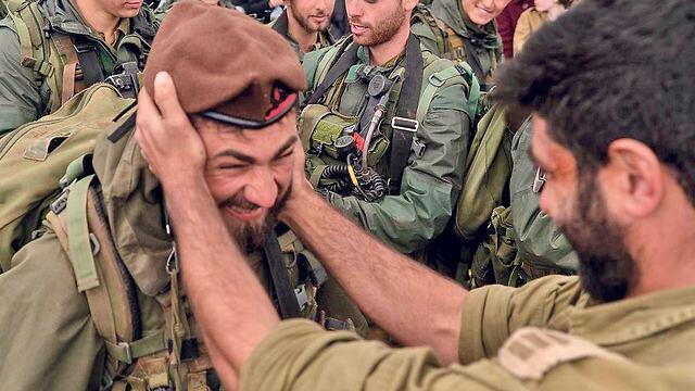 Shaker Kozly presents the coveted Golani brown beret to his younger brother Adam (Photo: IDF Spokesperson's Unit)
