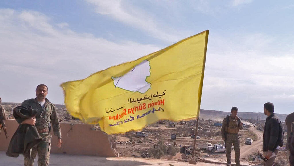 Photo: AFP כוחות סורים מניפים דגל אחרי כיבוש מוצב של דאעש