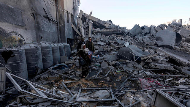 Palestinians inspect the damage caused by IAF strikes in Gaza, March 26, 2019 