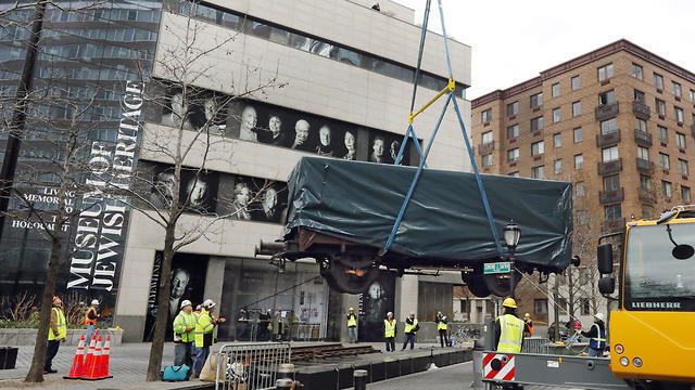 Cattle car used to transport Jews by the Nazis being lowered into place near the museum