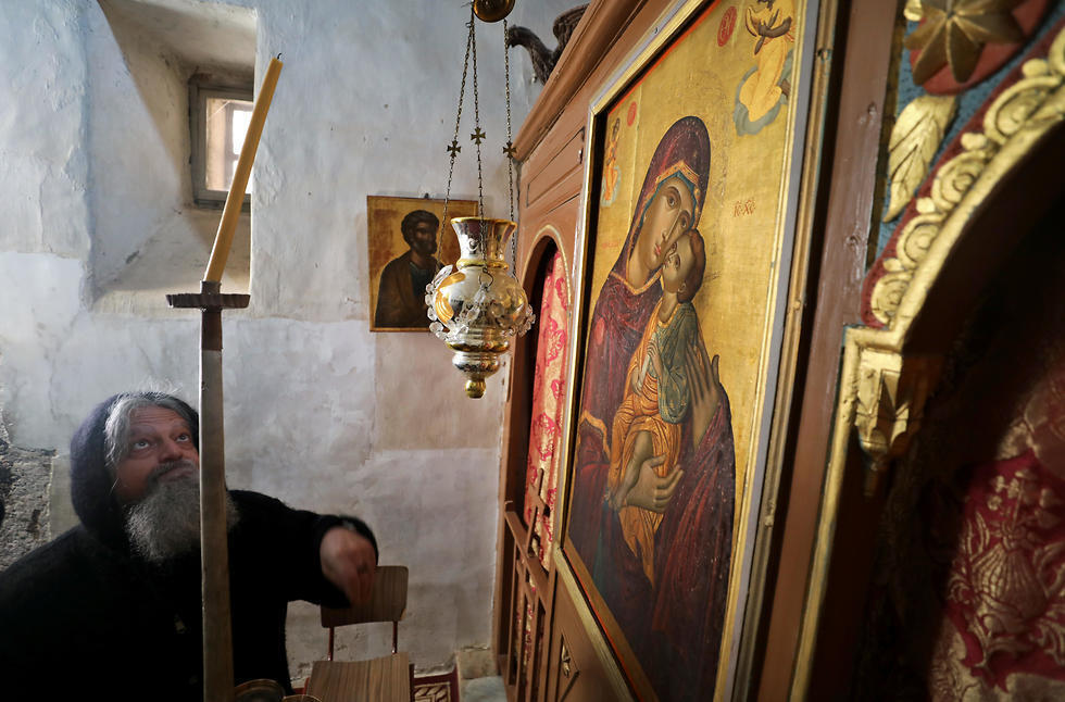 A monk adjusts a candle inside St Catherines Monastery
