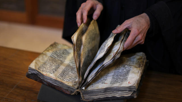 Librarian Father Justin of Sinai turns pages of a manuscript in the library of St Catherine's Monastery