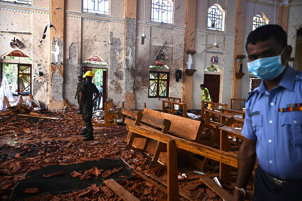 Security personnel inspect the interior of St. Sebastian's Church in Negombo on April 22, 2019