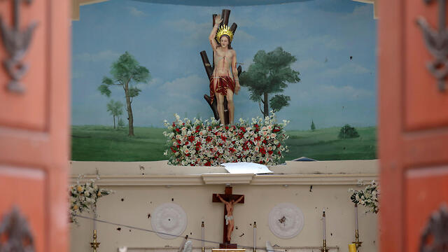 Blood stains are seen on a statue of Jesus Christ at St. Sebastian Catholic Church