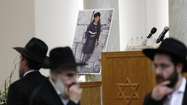 A couple embrace near a growing memorial across the street from the Chabad of Poway synagogue in Poway, Calif., on Monday