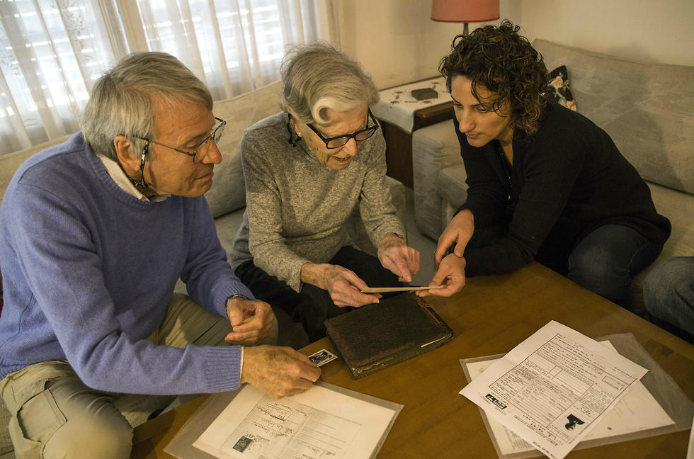 Holocaust survivors Rachel Zeiger 91, center, and her brother Moshe Akerman 84, left, speak with Orit Noiman, head of Yad Vashem's collection and registration center