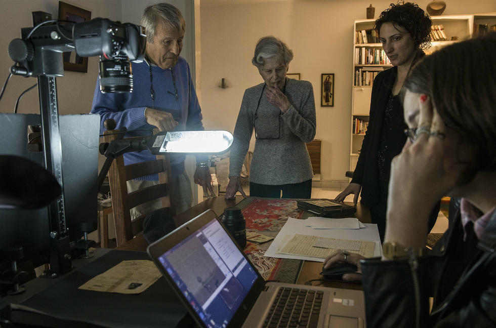 Zeiger, her brother Moshe Akerman and Orit Noima, head of Yad Vashem's collection and registration center, watch archivist Lena Shternberg reproduce holocaust era photographs and documents at their home