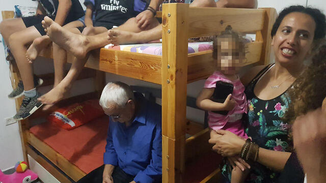 Blue and White MK Alon Schuster (center) sits in a bomb shelter at Kibbutz Nahal Oz 