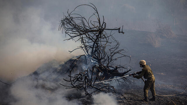Extinguishing a fire caused by incendiary balloons in the Gaza border area (צילום: AP) Extinguishing a fire caused by incendiary balloons in the Gaza border area
