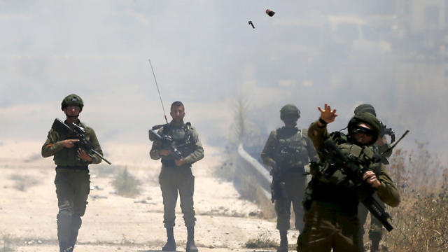 Border police forces use teargas to disperse Palestinian protesters during a rally against the American-led peace conference