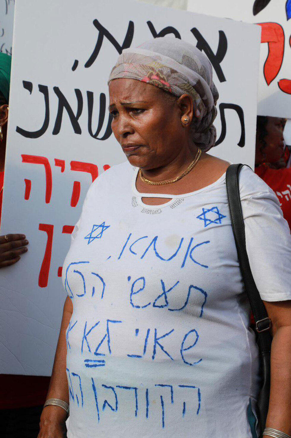 A protester in Tel Aviv. Her t-shirt reads: 'Mom, do everything you can to ensure I am not the next victim'
