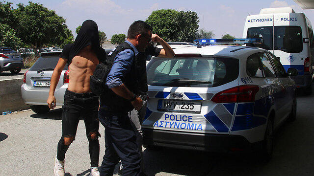 One of the Israeli rape suspects being escorted by Cypriot police