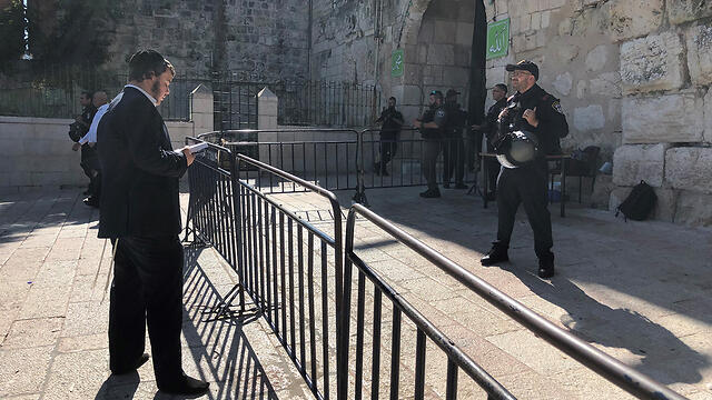A Jewish worshipper prays at the entrance to the Temple Mount in the Old City of Jerusalem on Tisha B'Av, August 11, 2019