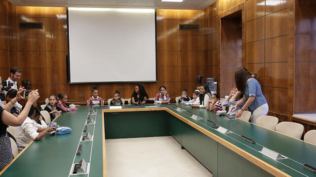 Young immigrants visit the room where the first-ever meeting of an Israeli government was held