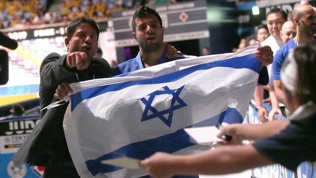 Judoka Sagi Muki and his coach Oren Smadja hold the Israeli flag after his World Championship win