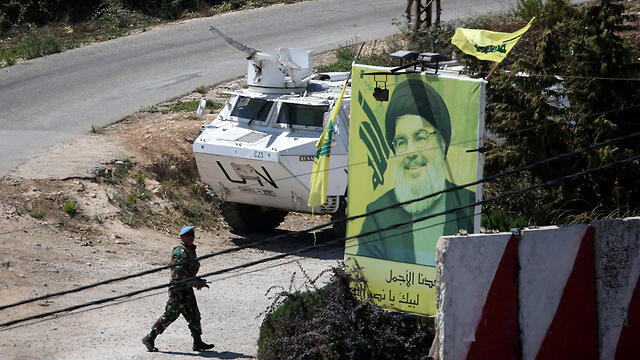 UNIFIL forces near a Hezbollah poster along the border (צילום: רויטרס) UNIFIL forces near a Hezbollah poster along the border