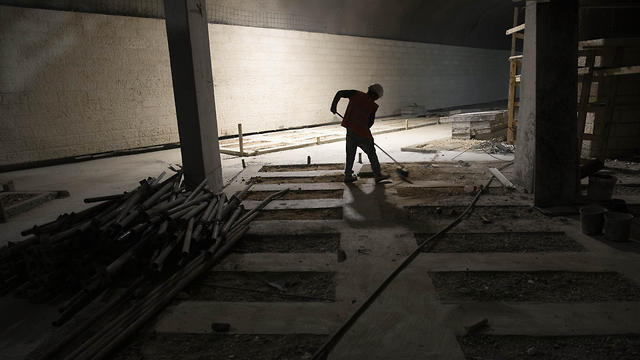 A worker cleans the floor at the construction site of a massive underground cemetery in Jerusalem, August 18, 2019 (Photo: AP) A worker cleans the floor at the construction site of a massive underground cemetery in Jerusalem, August 18, 2019