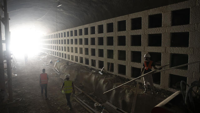 Workers walk at the construction site of a massive underground cemetery in Jerusalem, August 18, 2019 (Photo: AP) Workers walk at the construction site of a massive underground cemetery in Jerusalem, August 18, 2019