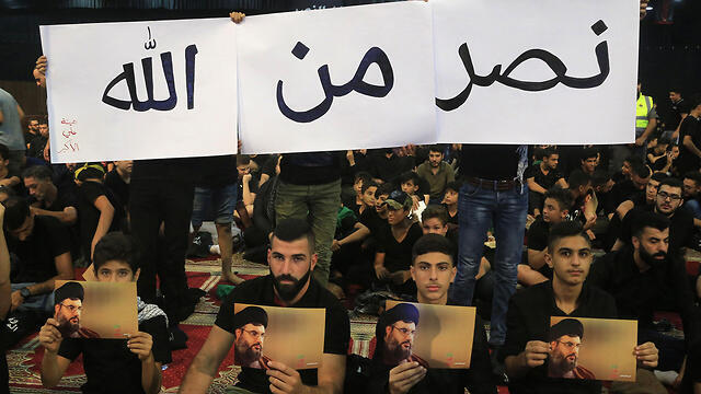 Hezbollah supporters watch Hassan Nasrallah's televised speech in Beirut