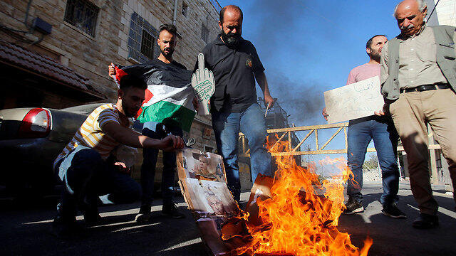 Palestinians burn Netanyahu's photo during his visit to Hebron (צילום: רויטרס) Palestinians burn Netanyahu's photo during his visit to Hebron