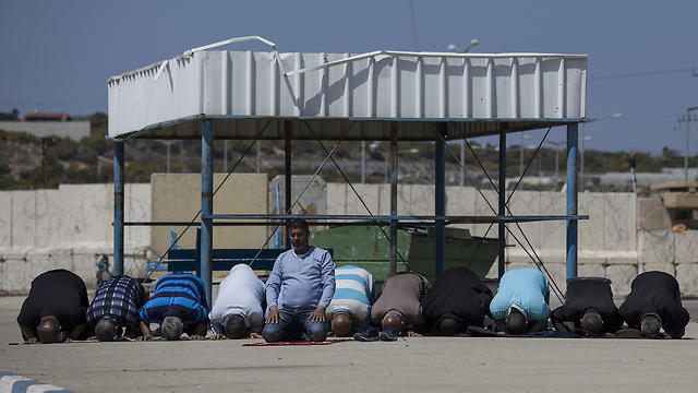 Palestinian workers pray at Erez crossing (Photo: AP) Palestinian workers pray at Erez crossing