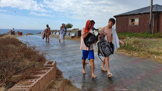 Beachgoers hide from rain in central Israel