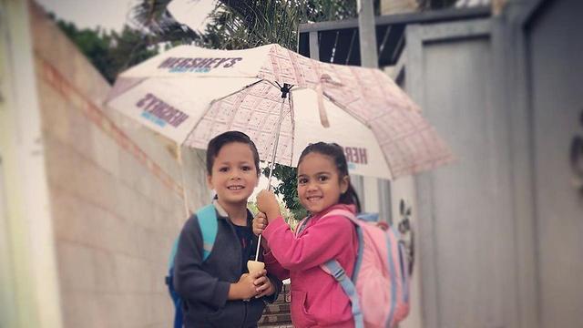 Children hide from rain in Eilat