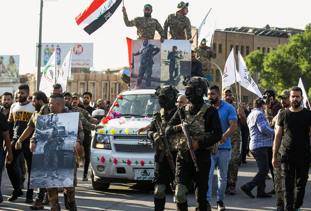 Members of the Popular Mobilization Forces militia parade through Baghdad with posters of fallen fighters during a demonstration against US military presence (Photo: AFP) עיראק מיליציה אל חשד א שעבי בגדד