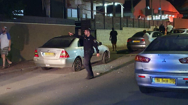 A policeman talks to local residents after a rocket barrage was fired at Sderot on Friday night
